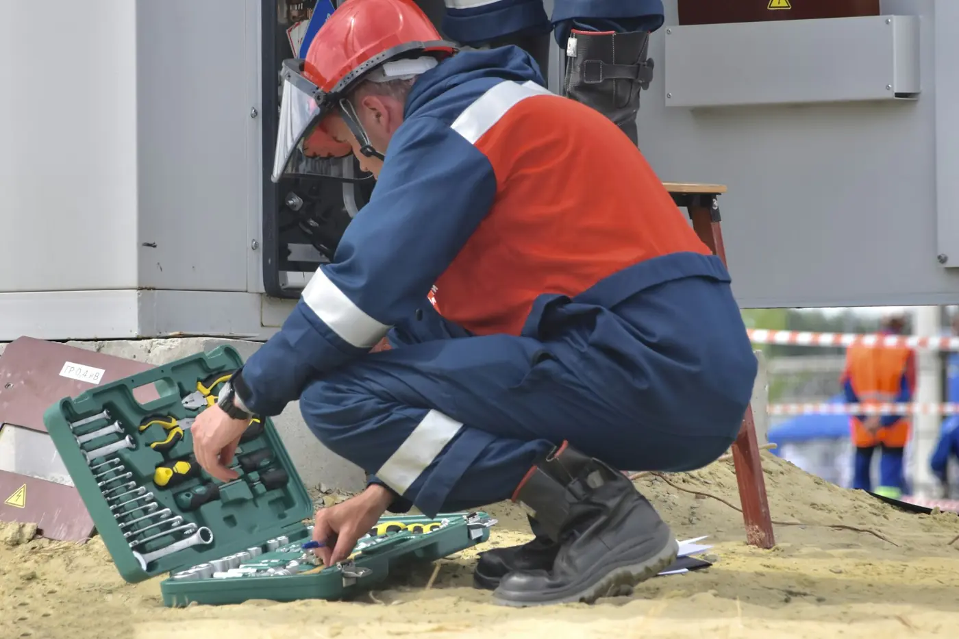 Technicien en tenue de travail avec sa caisse à outils